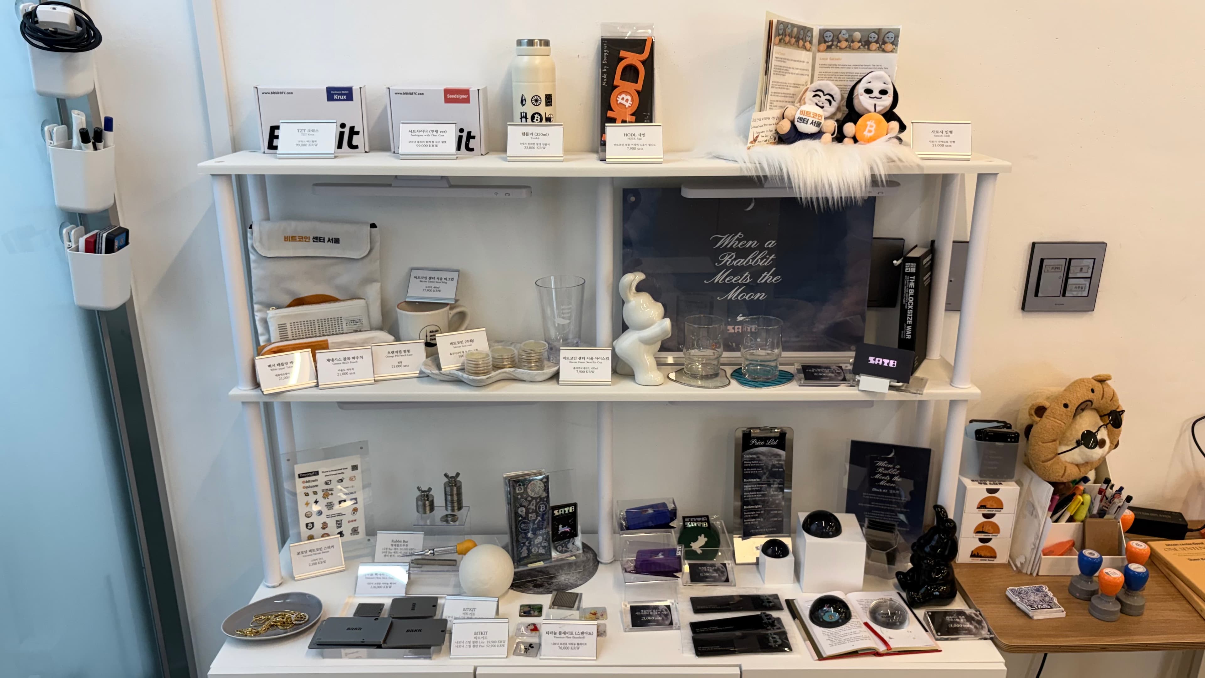 White shelves at the center holding Bitcoin-related objects and tools